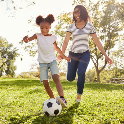 Mom playing soccer with daughter