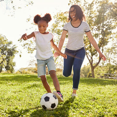 Mom and daughter playing soccer