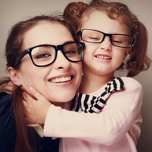 Mother and little girl wearing glasses and smiling