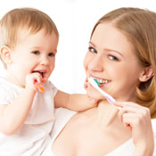 Mother and toddler brushing teeth together