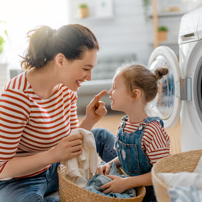 mom doing laundry with daughter