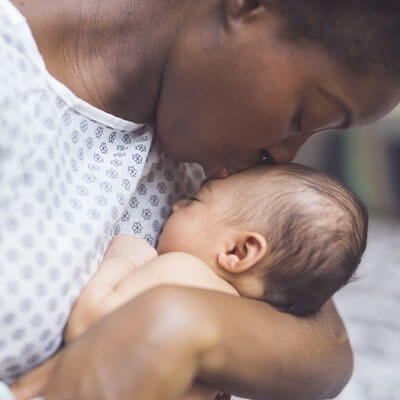 Mom kissing new baby