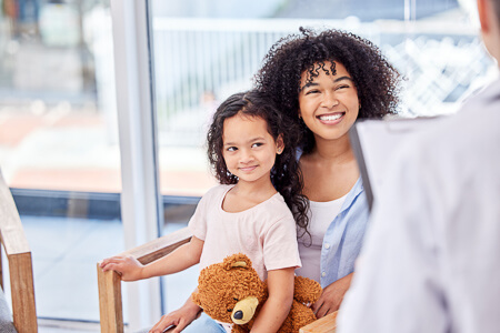 Mom and young daughter sitting in waiting room
