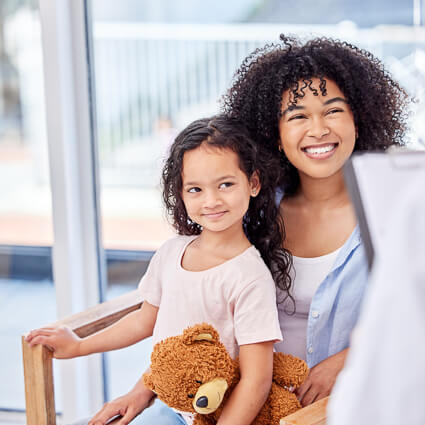 smiling mom with kid in lap sitting in chair