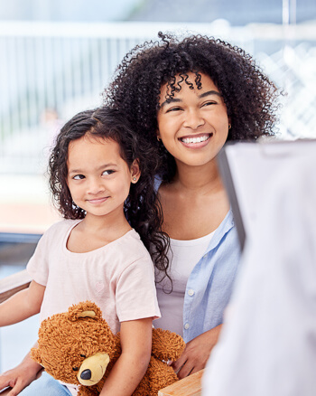 smiling mom talking with daughter on lap