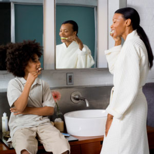 Mother and son brushing their teeth together