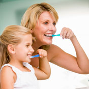 Mother and daughter brushing teeth together