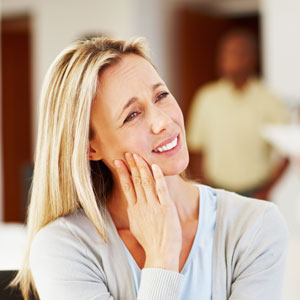 woman holding jaw in pain