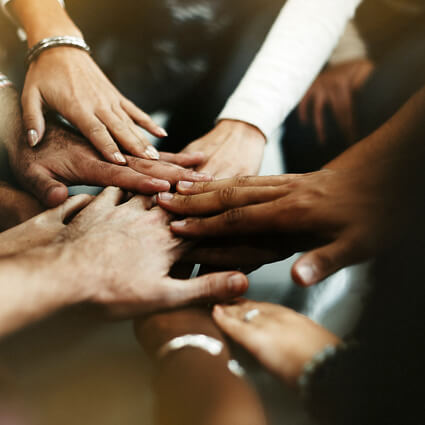 Several people's hands in a huddle
