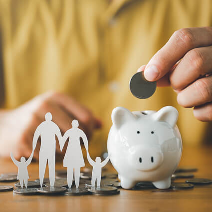 paper cutout of family next to piggy bank