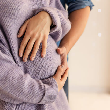 parents to be hugging womans stomach