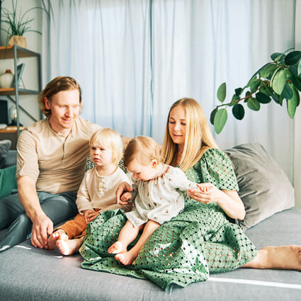 mom and dad with 2 kids sitting on a sofa