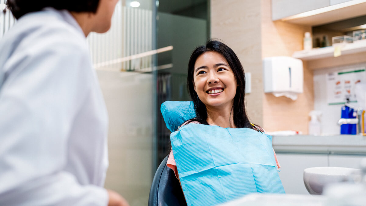 Patient at check up and clean appointment smiling at dentist