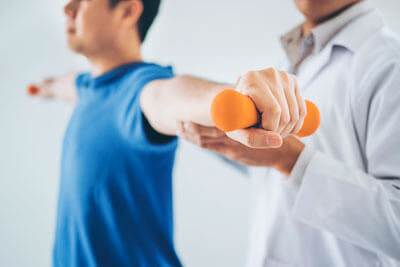 Doctor assisting man holding weight