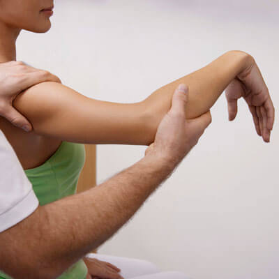 doctor helping woman stretch her arm