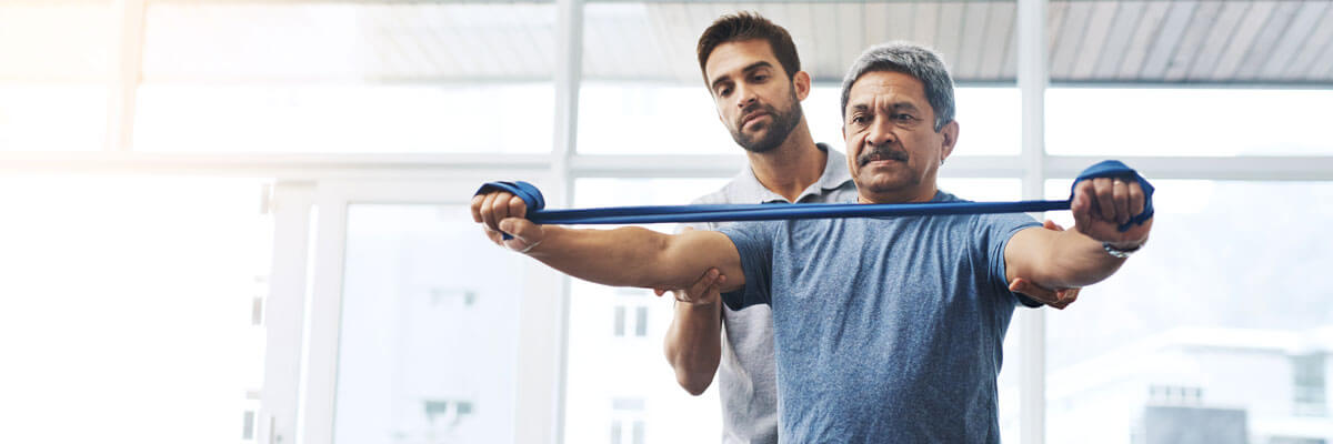 Physiotherapist guiding a patient through a resistance band exercise