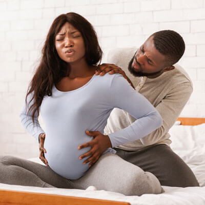 pregnant couple in pain on bed