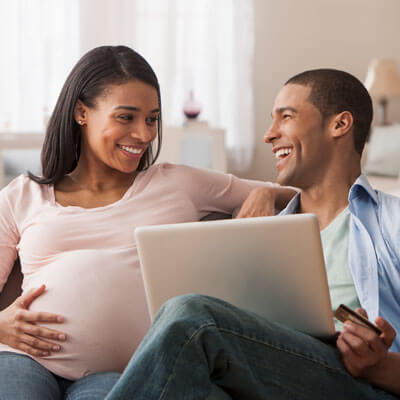 pregnant couple sitting on the couch