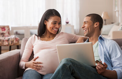 pregnant couple looking at computer