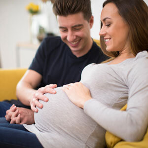 man and woman touching a pregnant stomach