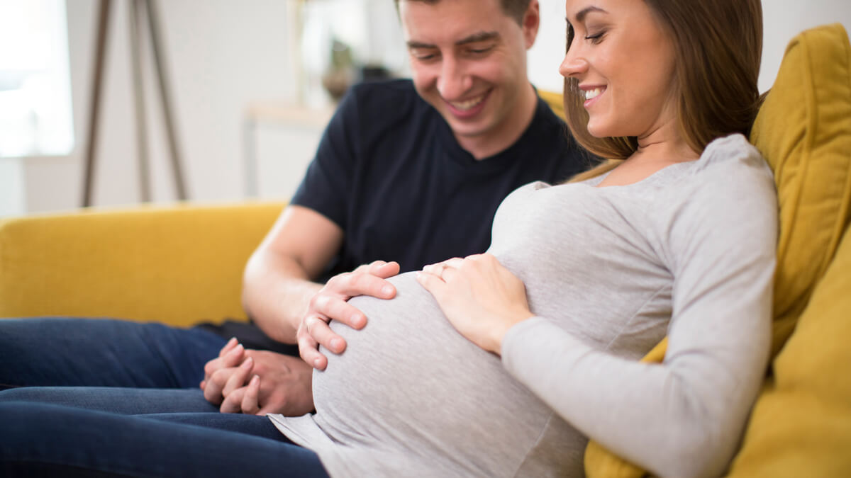 pregnant couple on couch