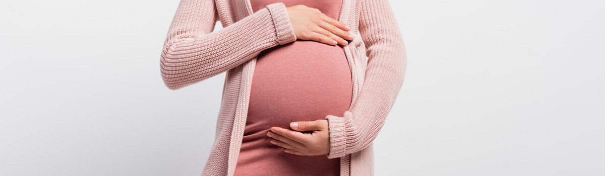 Pregnant woman with hands around belly