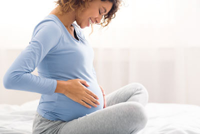 Pregnant woman looking at belly