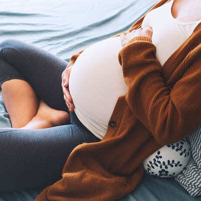 pregnant mom sitting on bed