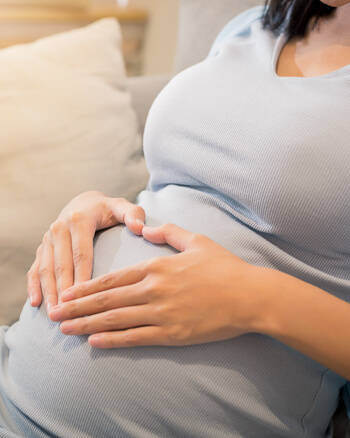 Pregnant woman making a heart sign on her belly