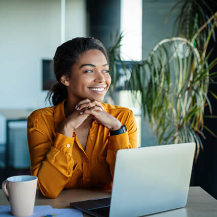 Smiling woman sitting in front of a laptop