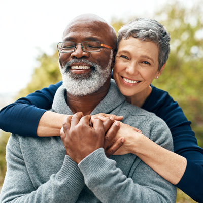two older people smiling and hugging