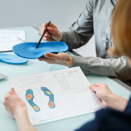 Chiropractor discussing orthotics with patient
