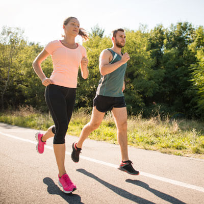 man and woman running on a road