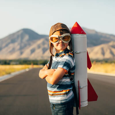 Child with toy rocket strapped to his back