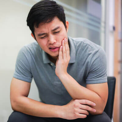 Man holding mouth in pain