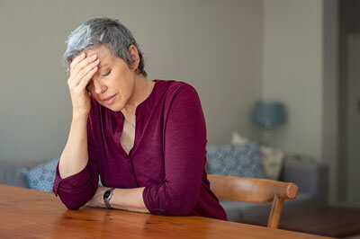 Woman sitting at table with headache