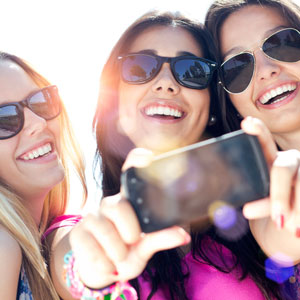 Three women smiling and taking selfie
