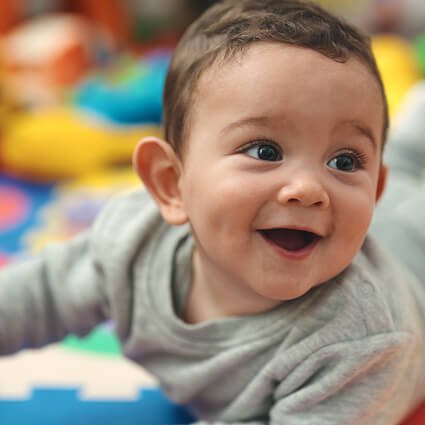 smiling boy playing on colorful floor