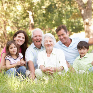 Smiling family posing in a grassy field