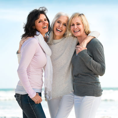 Three middle-aged women standing in beach