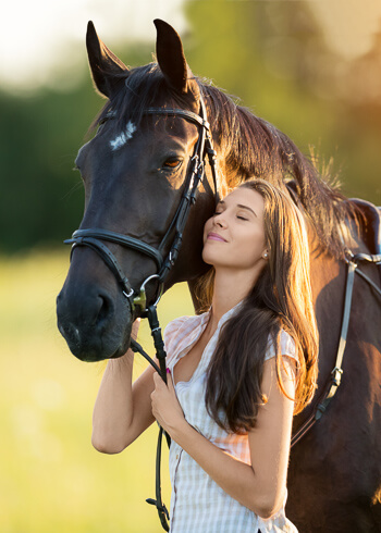 smiling woman petting horse