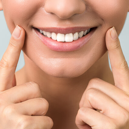 smiling woman with fingers on cheeks