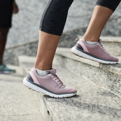 closeup of feet in sneakers walking up the stairs