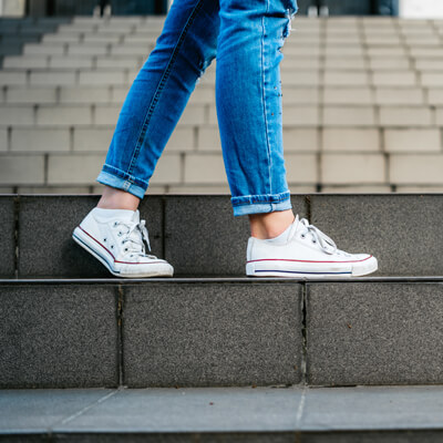 Woman with sneakers standing on stairs