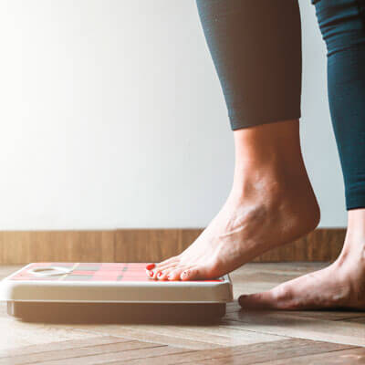 close up of womans feet stepping on scale