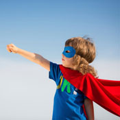 Little boy wearing superhero cape