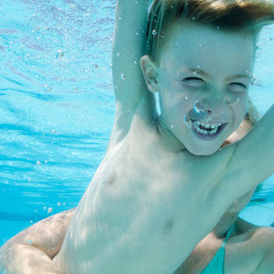 kid smiling and swimming