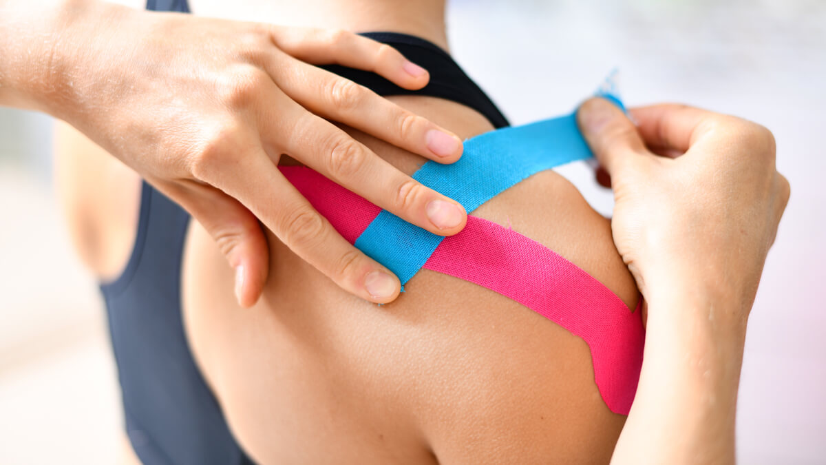 Taping woman's shoulder