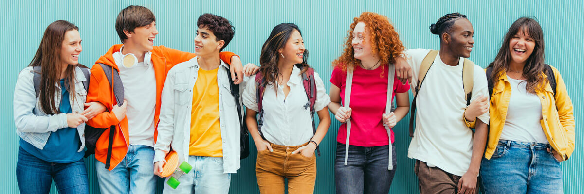 Teens leaning against a blue wall