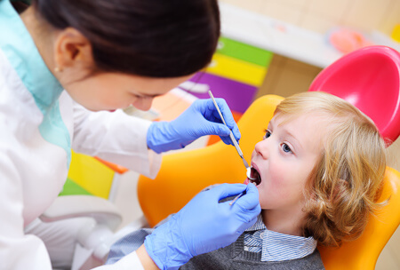 Toddler having a dental exam in a colourful office